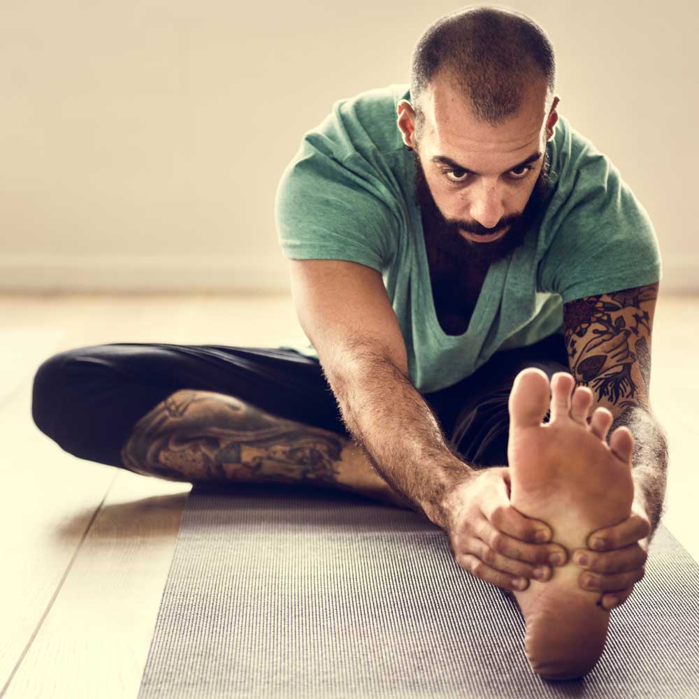 Man stretching during a pilates class